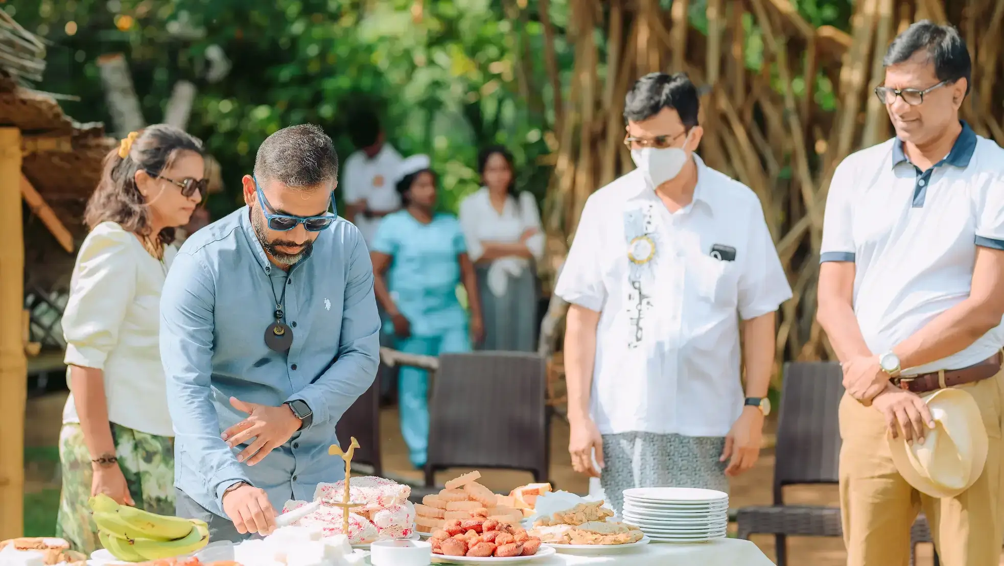A person is lighting an oil lamp that is on a table with few aurudu foods