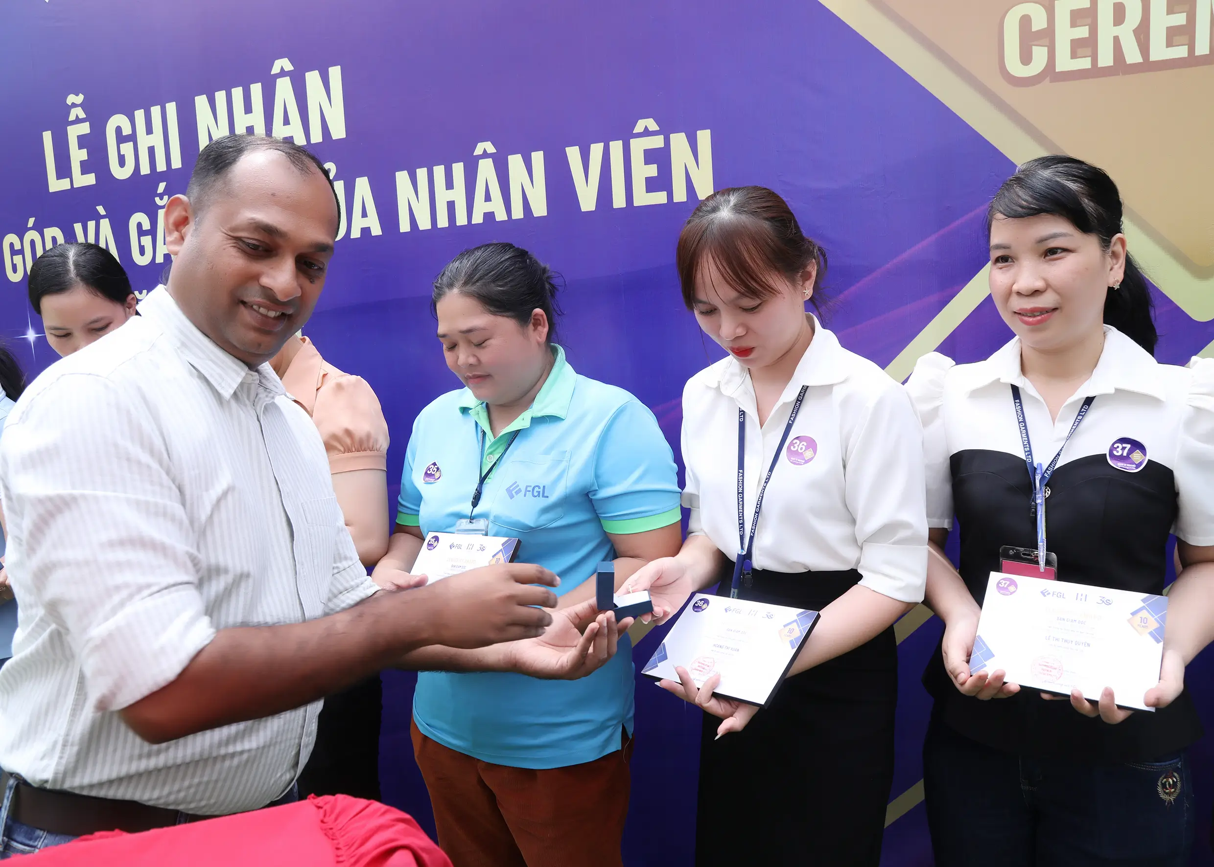 A manager handing over the certificates and gifts in the event of seniority awards