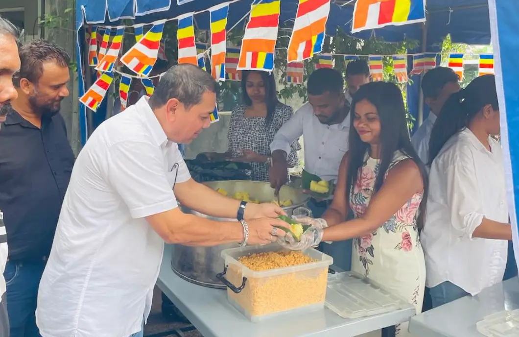 An employee of Hirdaramani handing over some foods to another person